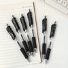 Black good gel pens placed on a notebook, ideal for smooth and professional writing.